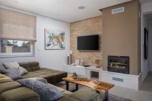 a living room with a couch and a fireplace at Villa with pool near sandy beach - by TRAVELER tourist agency Krk - ID 2224 in Privlaka