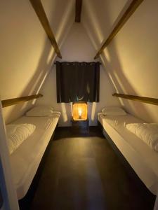 a room with two beds and a window with a candle at Chalet 23 in Durbuy +18 photos