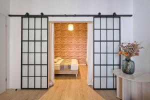 a bedroom with a bed through a sliding glass door at Urban Nest Apartments Szewska 21 in Kraków