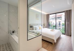 a bedroom with a bed and a bathroom with a mirror at The Royal Vista - Phu My Hung in Ho Chi Minh City +31 photos