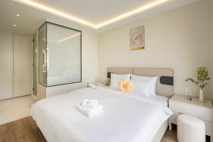 a bedroom with a large white bed with a mirror at The Royal Vista - Phu My Hung in Ho Chi Minh City
