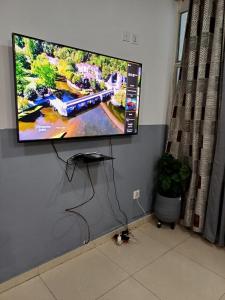 a flat screen tv hanging on a wall at Luxiaa Apartments LTD in Lemba-Gaba