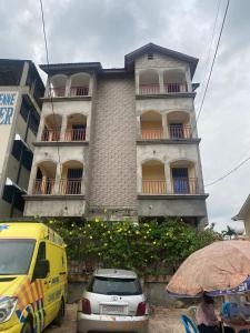 a building with cars parked in front of it at Luxiaa Apartments LTD in Lemba-Gaba