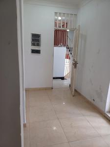 a hallway with a staircase and a room with white walls at Luxiaa Apartments LTD in Lemba-Gaba