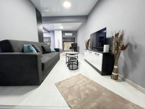Una sala de estar con un sofá y un televisor. en NJ Luxury Room, en Varna