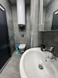 Un baño con un lavabo blanco y un inodoro. en NJ Luxury Room, en Varna