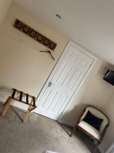 a room with a white door and a chair at The Castle Inn in Usk