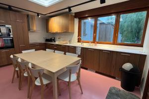 a kitchen with a wooden table and white chairs at Grande Maison 17 personnes in Arras