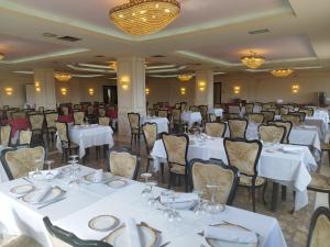 a banquet hall with white tables and chairs at Hotel Dracos in Cebreros