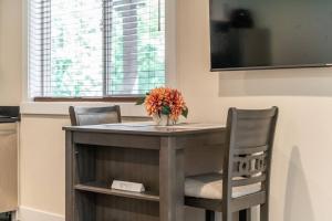 una mesa con dos sillas y un jarrón con flores. en Serene 1 Bdrm, 1 Bath Apartment, en Seattle