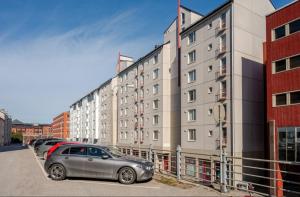 a car parked in a parking lot in front of buildings at Moderni yksiö parvekkeella,, erinomainen sijainti in Helsinki