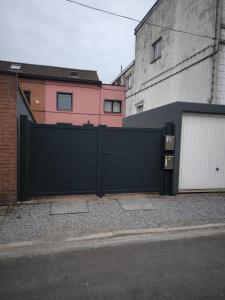 a black garage door in front of a building at Maison entière privée in Charleroi