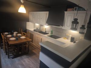 a kitchen with a table and a kitchen with white cabinets at Maison entière privée in Charleroi +26 photos