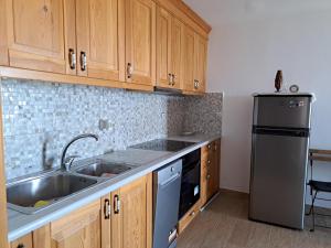 a kitchen with a sink and a refrigerator at Blue Fox 2 in Chrani +16 photos