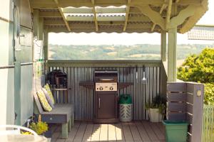a patio with a grill and a table and bench at Bluebird Penthouse & Land Rover Hot Tub in High Bickington