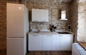 a kitchen with white cabinets and a white refrigerator at La Maison del Borgo in Castiglioni +41 photos