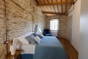 a bedroom with a bed in a brick wall at La Maison del Borgo in Castiglioni