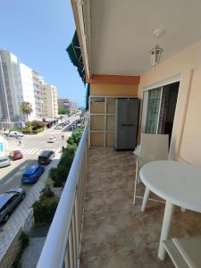 a balcony of a building with a table and a street at Oasis Playa de Gandía in Gandía