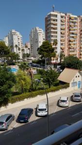 a group of cars parked on a street with buildings at Oasis Playa de Gandía in Gandía