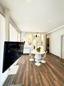 uma sala de estar com uma televisão e uma mesa e cadeiras em Acropolis view em Atenas