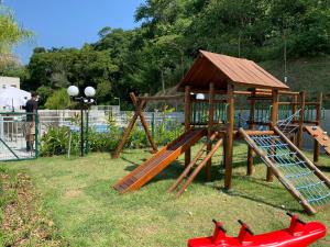 里约热内卢Conforto e natureza no Rio de Janeiro的一个带滑梯和木游戏结构的游乐场
