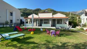 a yard with chairs and tables and a house at Harmony Studios & Apartments in Skala Potamias