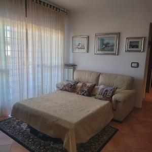 a living room with a bed and a couch at Alloggio per uso turistico ECM Giardino di Roma in Vitinia