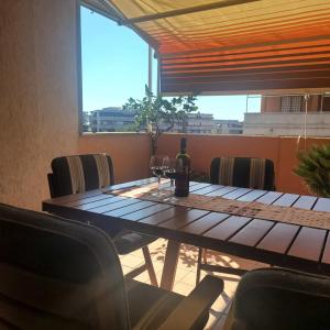 a table with a bottle of wine and two glasses at Alloggio per uso turistico ECM Giardino di Roma in Vitinia