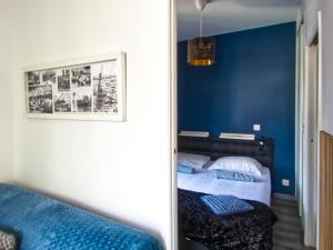 a bedroom with blue walls and a bed with a mirror at La petite Maison in Grenoble