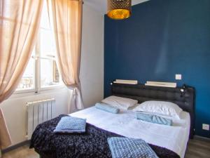 a bedroom with a bed with blue walls and a window at La petite Maison in Grenoble