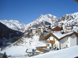 ein Dorf im Schnee mit Bergen im Hintergrund in der Unterkunft Chasa Valetta in Samnaun