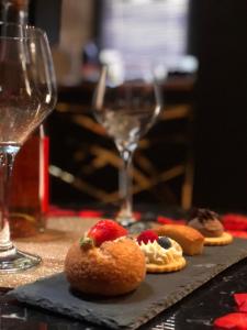 a table with a plate of food and a glass of wine at L’Aphrodizia love room in Barbaste