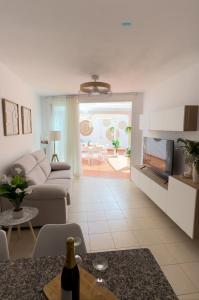 een woonkamer met een bank en een tafel bij Vamos Tenerife - Playa La Arena - Puerto De Santiago in Puerto de Santiago
