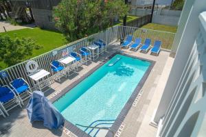 an overhead view of a swimming pool with blue chairs at Marisol Condo 301 in South Padre Island