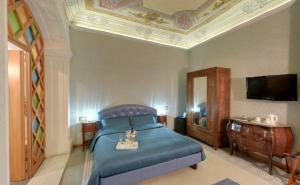 Un dormitorio con una cama azul y un televisor. en B&B Cavour10 Firenze, en Florencia 26 fotos más