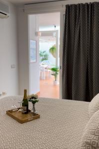 een fles wijn en bloemen op een bed bij Vamos Tenerife - Playa La Arena - Puerto De Santiago in Puerto de Santiago