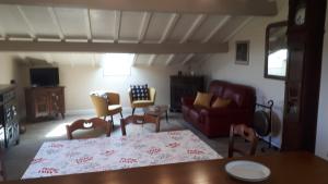 a living room with a red couch and chairs at Maison GAINEKO ETXEA in Ostabat-Asme