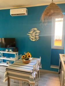 a dining room with a table and a blue wall at Luna D'Argento Apartment in Porto Ercole