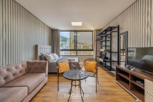 uma sala de estar com um sofá, uma mesa e cadeiras em SSG - Estúdios próximos a UFSC em Florianópolis em Florianópolis