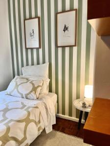 una camera da letto con pareti a righe verdi e bianche e un letto di Casa da 25 a Espinho