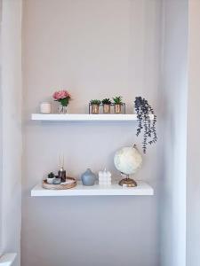 ein weißes Regal mit Pflanzen und Vasen darauf in der Unterkunft Modern Comforts in Cleethorpes in Cleethorpes