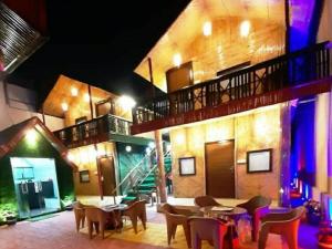 a restaurant with tables and chairs in a building at Hotel Arcadia plutus in Jaipur