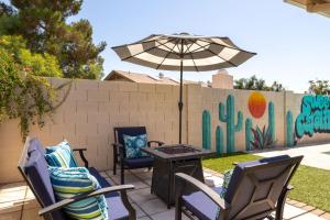 un patio con sedie e un tavolo con un ombrellone di The Fashionable Fox Trotter with Heated Pool a Phoenix
