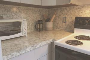 a kitchen with a white microwave and a stove at Downtown, Near RISD & Train, Walk Everywhere in Providence
