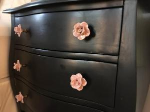 a black dresser with pink flowers on it at Downtown, Near RISD & Train, Walk Everywhere in Providence