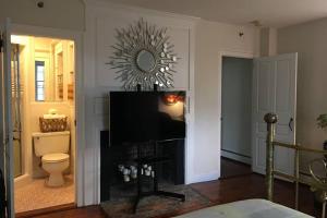 a living room with a television and a toilet at Downtown, Near RISD & Train, Walk Everywhere in Providence