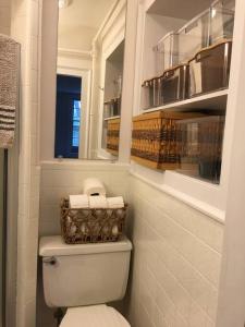 a bathroom with a toilet with a basket of towels at Downtown, Near RISD & Train, Walk Everywhere in Providence +9 photos