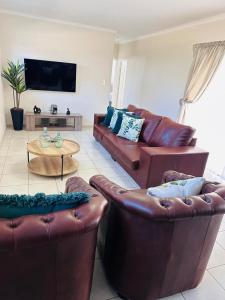 a living room with two leather couches and a table at 02 in Bel Aire place in Kempton Park