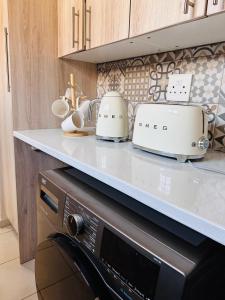 a kitchen counter with two toasters on top of a microwave at 02 in Bel Aire place in Kempton Park +6 photos