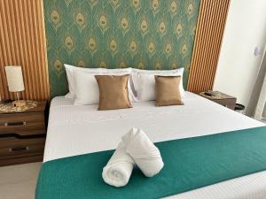 a bed with a pair of white slippers on it at Hotel Punta Colibrí in Puerto Escondido